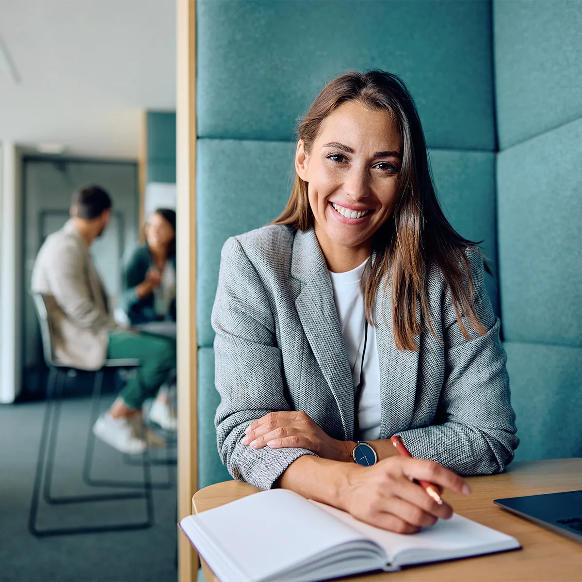 Person sitzt lächelnd am Schreibtisch
